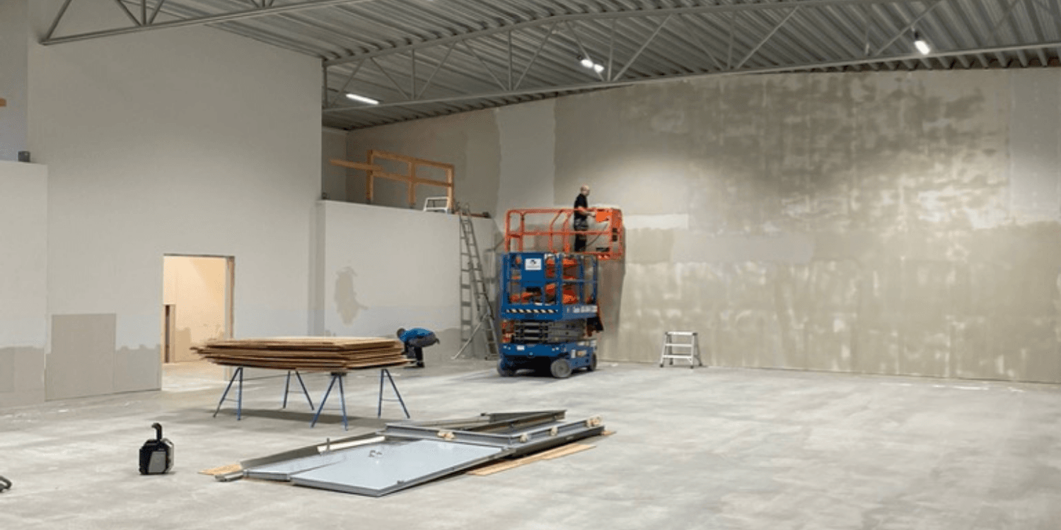 Stor kontorslokal med pågående målning – ytskiktsförberedelse som del av en större kontorsanpassning.