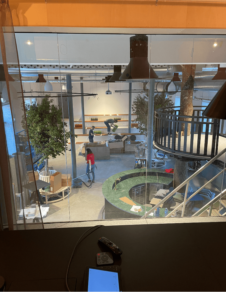 Vy från övre plan över lounge, bar och byggarbete – visar hur ytorna växer fram och färdigställs i slutskedet av projektet.